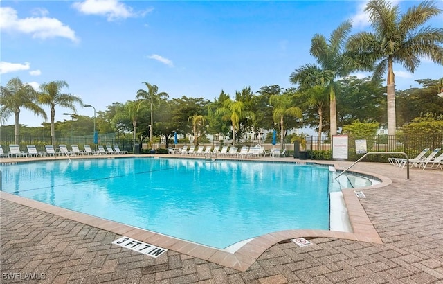 community pool featuring fence and a patio