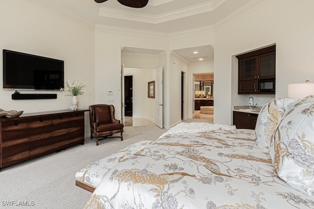 bedroom featuring ceiling fan, sink, ornamental molding, light carpet, and ensuite bath