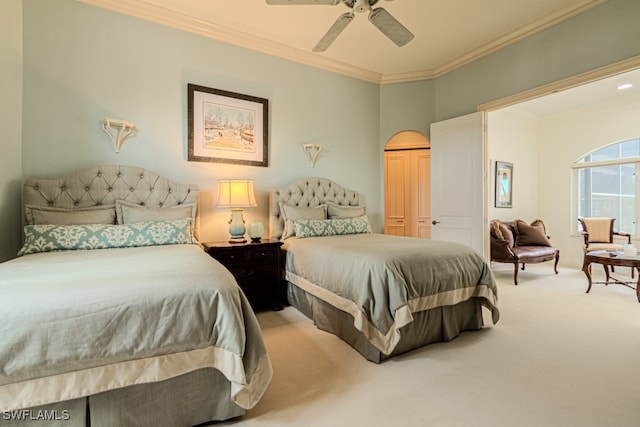 carpeted bedroom featuring ceiling fan, a closet, and ornamental molding