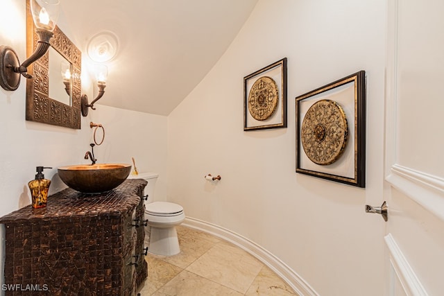 bathroom with vaulted ceiling, vanity, and toilet