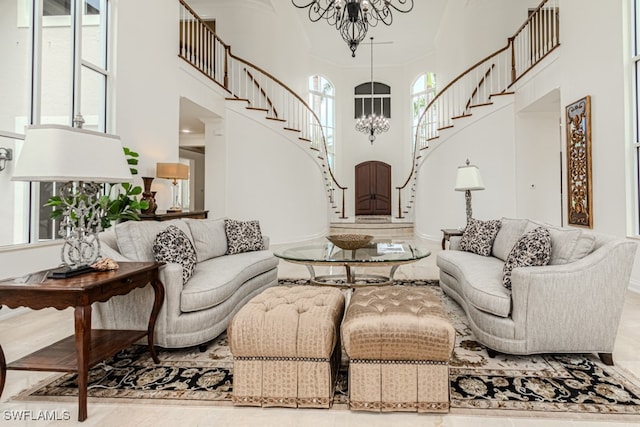 living room featuring a high ceiling, a chandelier, and crown molding