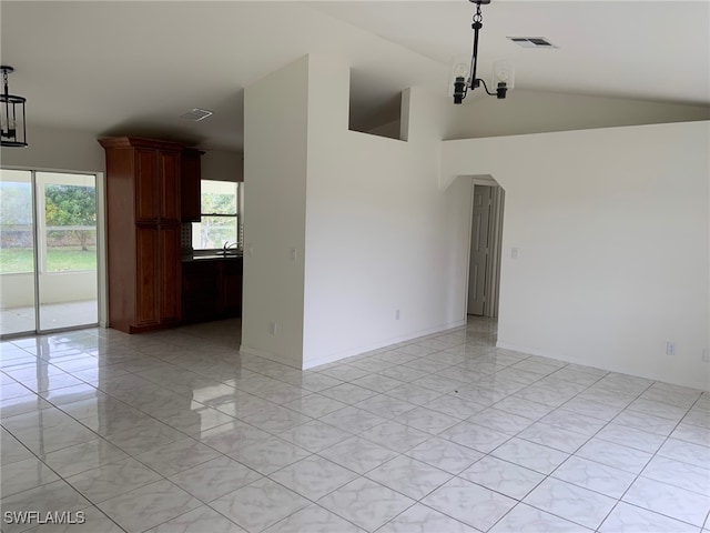 spare room featuring vaulted ceiling and an inviting chandelier