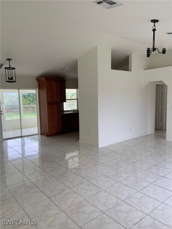 unfurnished room featuring an inviting chandelier