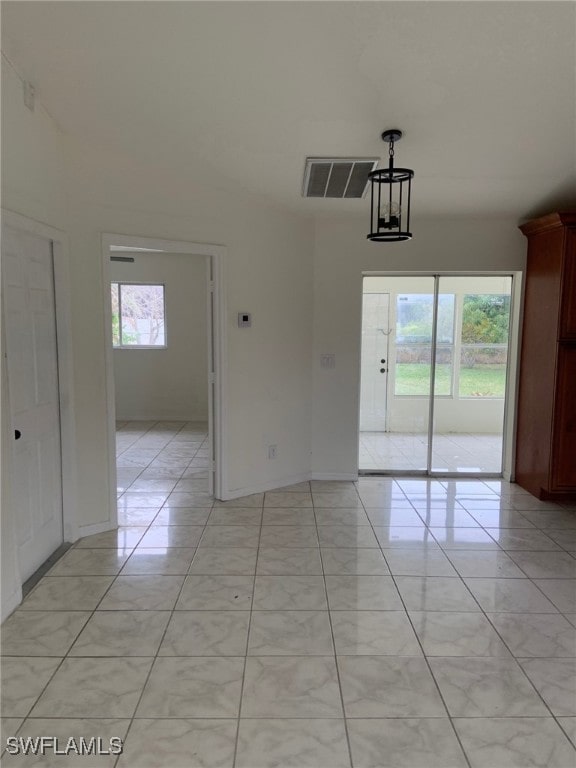 unfurnished dining area featuring plenty of natural light and a notable chandelier