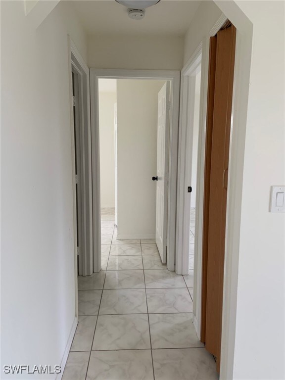 1115 SW 6th Ct, Cape Coral, FL 33991 - hallway featuring light marble finish floors