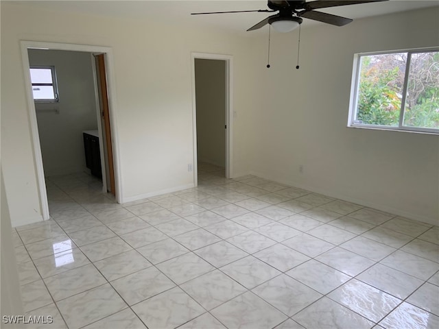 tiled spare room featuring ceiling fan