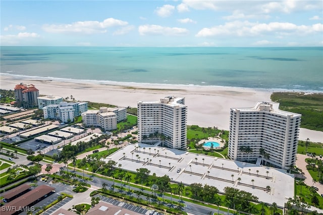 birds eye view of property with a water view and a beach view