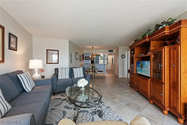 living room featuring a notable chandelier, a textured ceiling, and light tile patterned floors