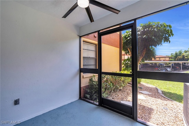 unfurnished sunroom with ceiling fan