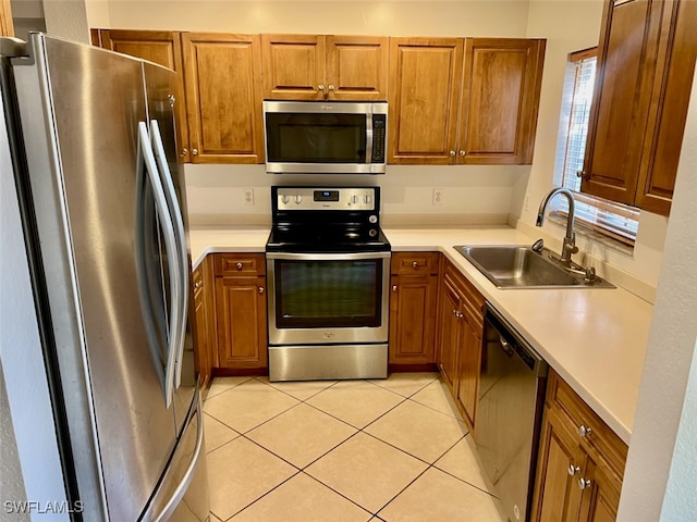 kitchen featuring appliances with stainless steel finishes, light tile patterned flooring, and sink