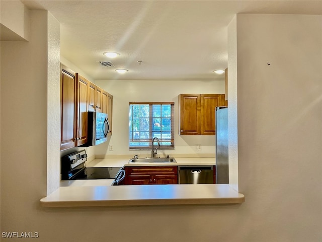 kitchen featuring stainless steel appliances, sink, and kitchen peninsula