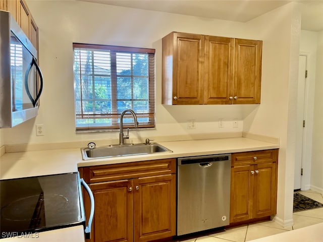 kitchen featuring appliances with stainless steel finishes, sink, and light tile patterned floors