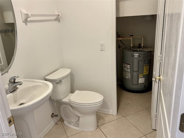 bathroom featuring electric water heater, tile patterned floors, and toilet