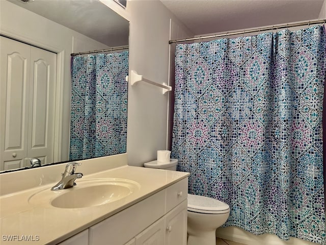 bathroom featuring curtained shower, vanity, and toilet