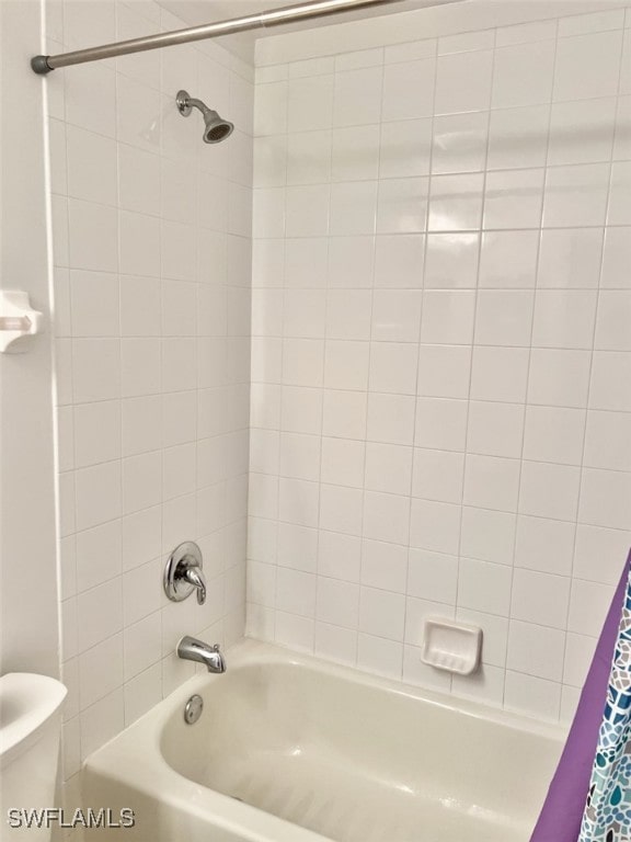 bathroom with shower / bathtub combination with curtain and toilet