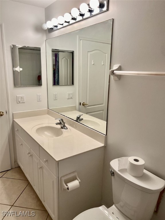 bathroom with tile patterned flooring, vanity, and toilet