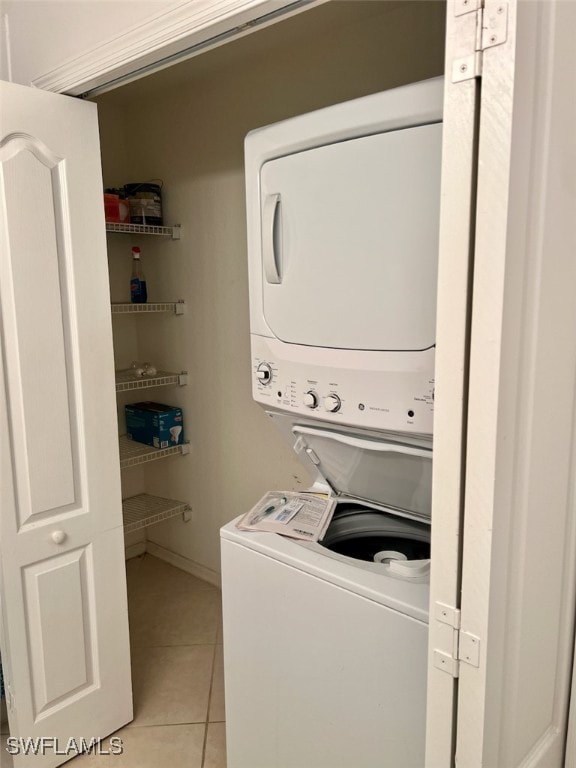 laundry area with stacked washer and dryer and light tile patterned floors