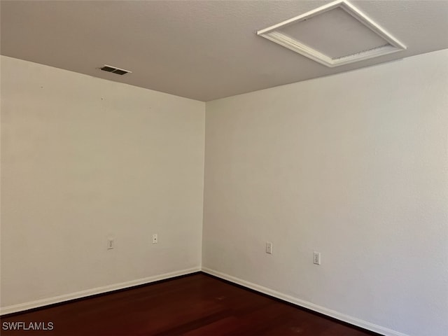 spare room featuring dark wood-type flooring