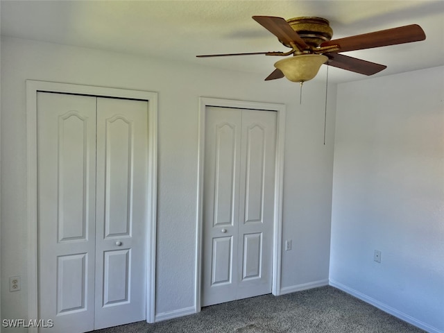 unfurnished bedroom with carpet, multiple closets, and ceiling fan