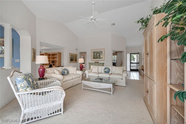 living room featuring decorative columns, light colored carpet, high vaulted ceiling, and ceiling fan