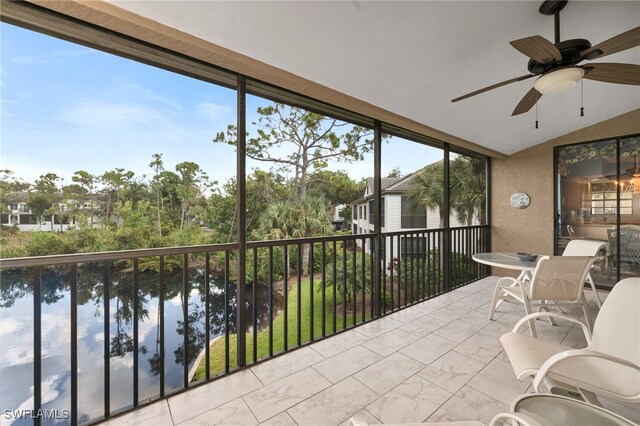 sunroom with lofted ceiling, a water view, and ceiling fan