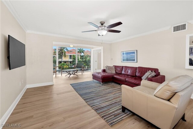 living room featuring crown molding, ceiling fan, and light wood-type flooring