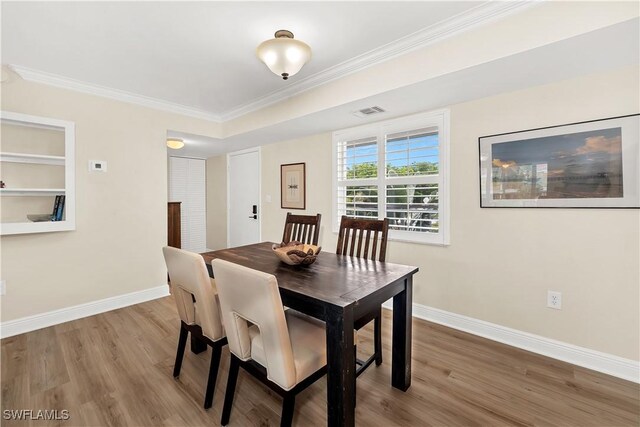 dining area featuring light wood-type flooring and ornamental molding