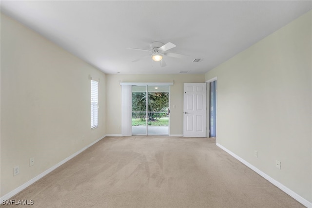 spare room featuring light carpet and ceiling fan