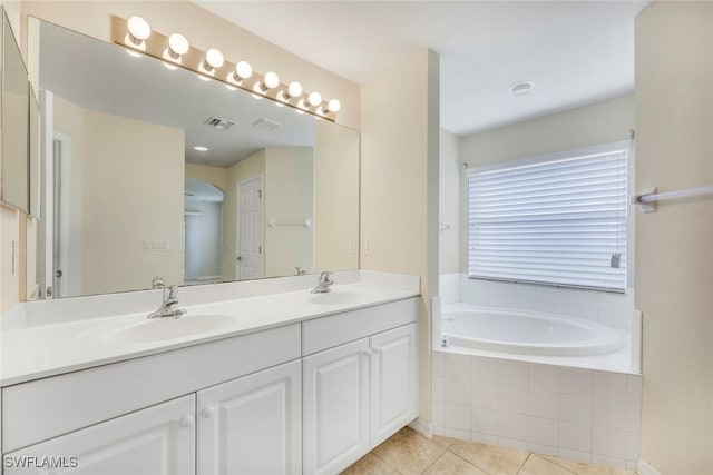 bathroom featuring vanity, tiled bath, and tile patterned flooring