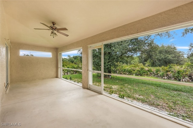 unfurnished sunroom featuring ceiling fan