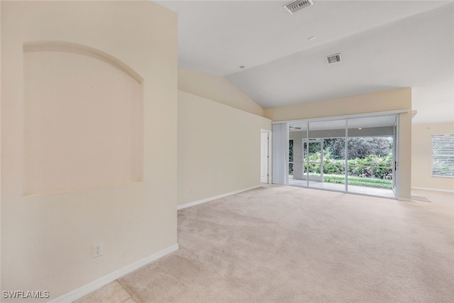 carpeted empty room featuring vaulted ceiling