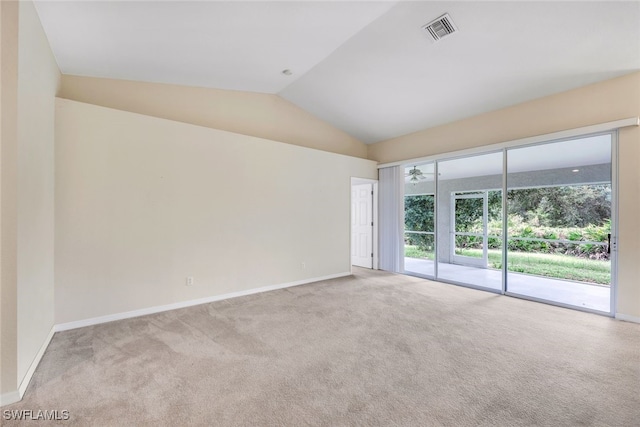 carpeted empty room with vaulted ceiling