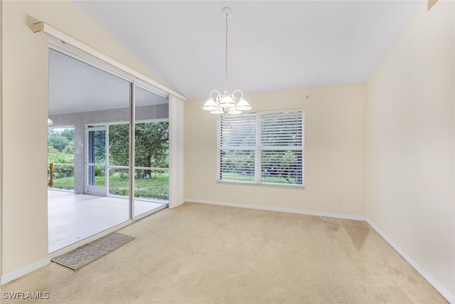 carpeted spare room featuring an inviting chandelier