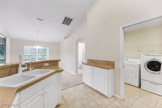 kitchen featuring white cabinetry, independent washer and dryer, decorative light fixtures, sink, and a notable chandelier