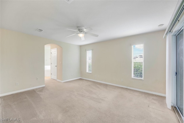 spare room with ceiling fan and light colored carpet