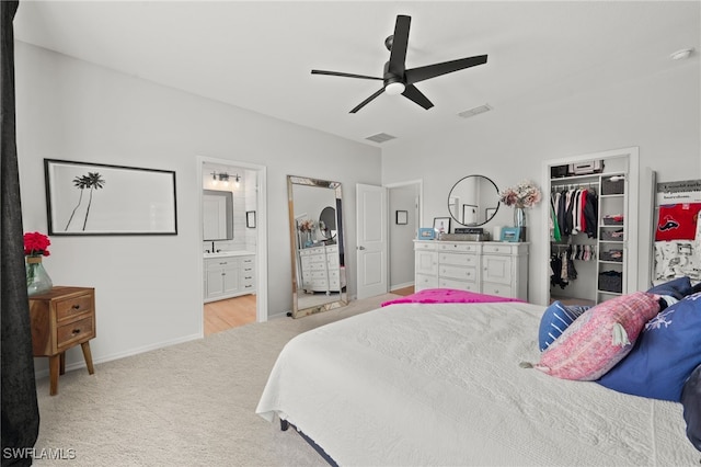 carpeted bedroom featuring a spacious closet, ensuite bath, a closet, and ceiling fan