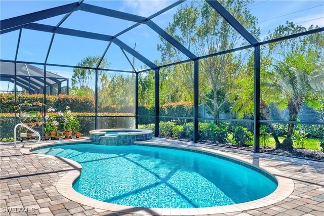 view of pool featuring a lanai, an in ground hot tub, and a patio area