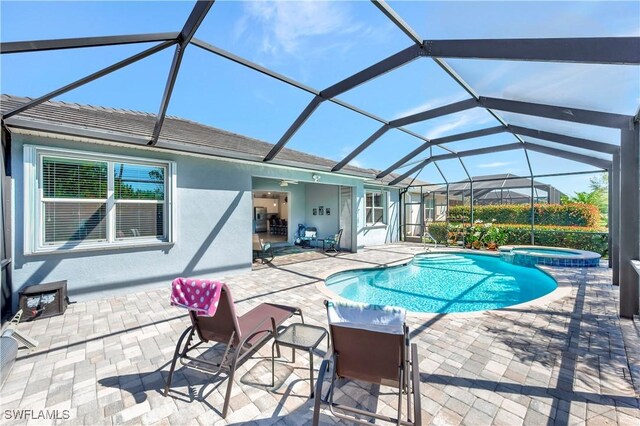 view of pool with a lanai, an in ground hot tub, and a patio