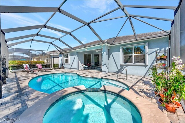 view of pool with an in ground hot tub, glass enclosure, and a patio area