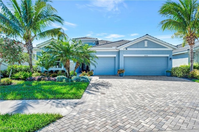 view of front of home featuring a tile roof, decorative driveway, an attached garage, and stucco siding