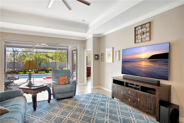 tiled living room with ornamental molding, ceiling fan, and a raised ceiling