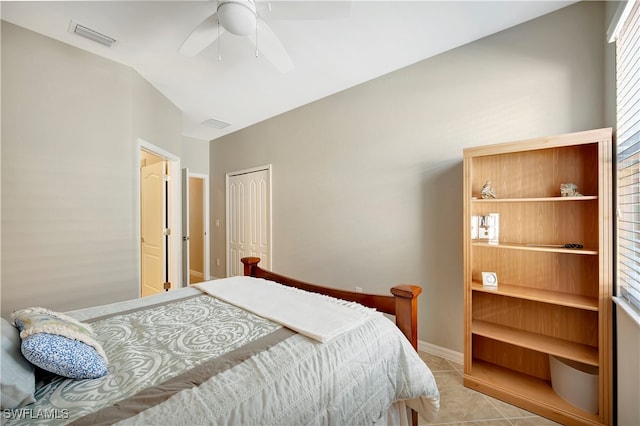 bedroom featuring light tile patterned floors, vaulted ceiling, ceiling fan, and a closet