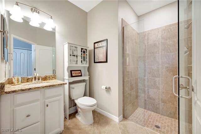 bathroom with vanity, toilet, tile patterned floors, and a shower with shower door