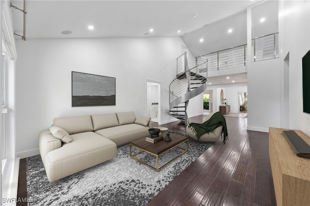 living room with hardwood / wood-style floors and a towering ceiling