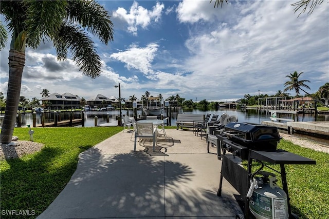 view of patio with area for grilling, a water view, and a dock