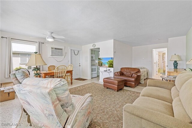 living room featuring a wall unit AC and ceiling fan