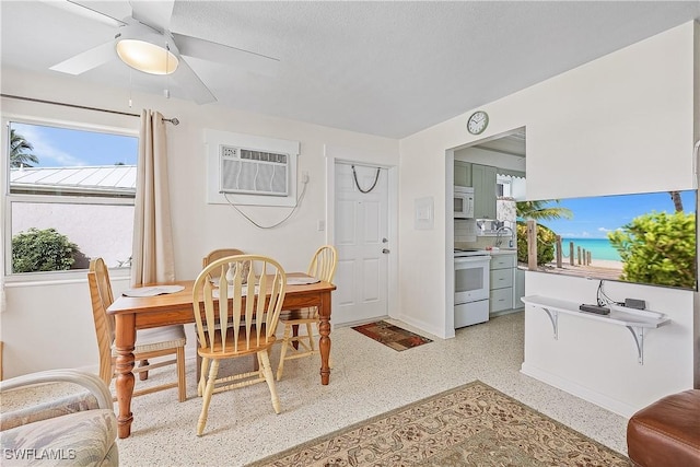 dining space with ceiling fan, sink, and a wall mounted AC