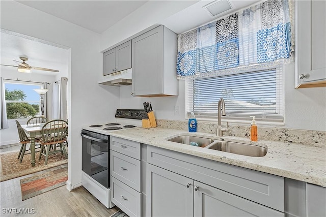 kitchen with gray cabinetry, sink, electric range, ceiling fan, and light stone countertops