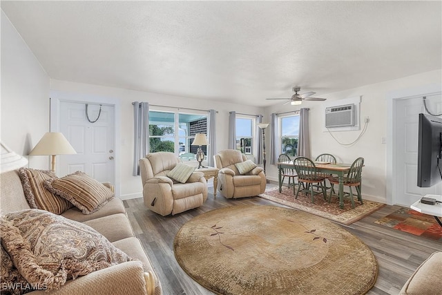 living room featuring hardwood / wood-style flooring, plenty of natural light, and a wall mounted AC