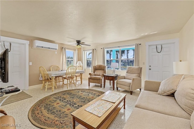 living room featuring a wall unit AC, a wealth of natural light, and ceiling fan